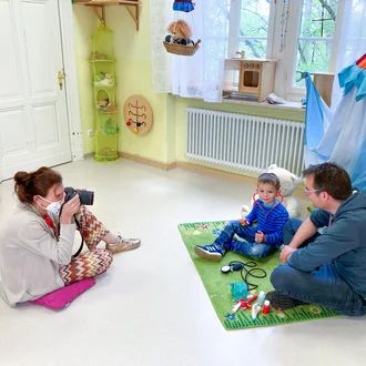 Fotografin begleitet ein Kind beim Doktorspiel mit einem Erwachsenen im Kita-Setting – Behind-the-Scenes-Moment der Employer-Branding-Kampagne des Klinikverbund Allgäu.