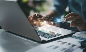 Ein digitales Interface mit Fokus auf Suchmaschinenoptimierung (SEO) erscheint über der Tastatur eines Laptops. Eine Person arbeitet konzentriert mit Laptop, Tablet-Stift und Business-Dokumenten. Die holografischen Icons symbolisieren digitale Strategien wie Keyword-Recherche, Content-Marketing, Datenanalyse und Ranking-Optimierung.